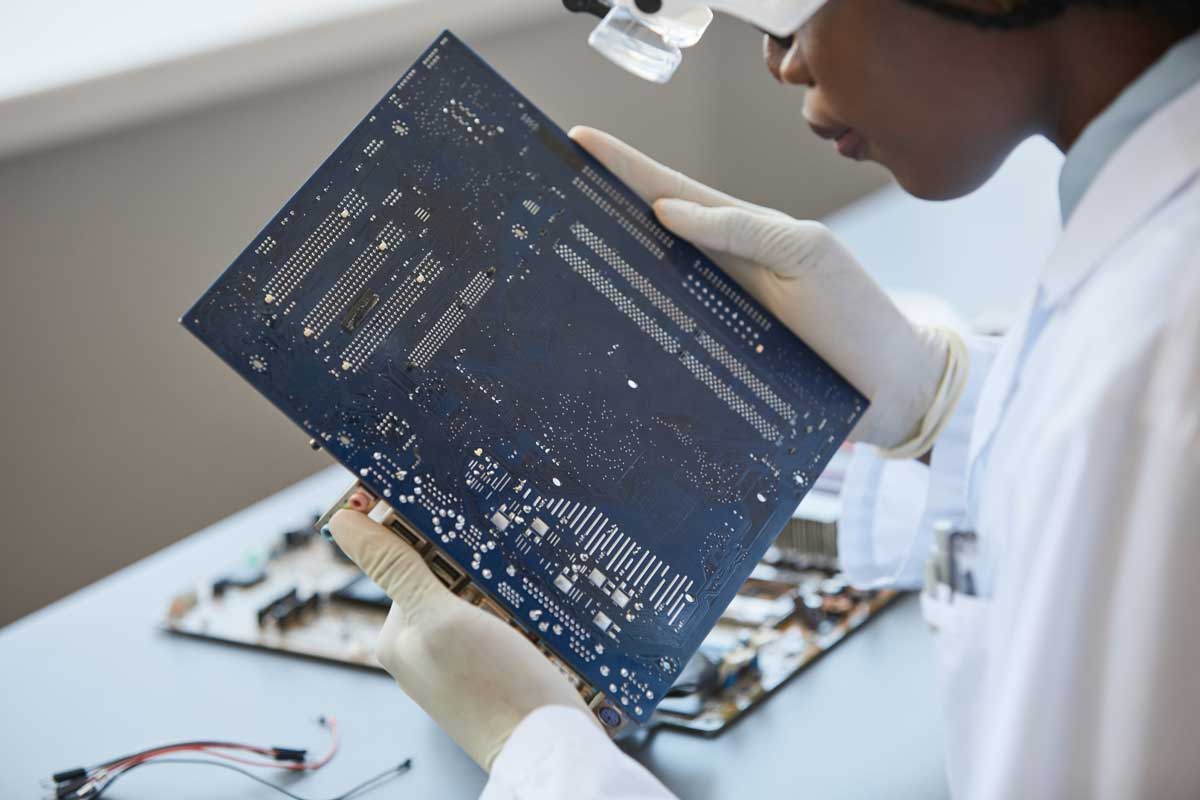 a woman in a lab inspecting pcb material